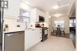 Kitchen featuring appliances with stainless steel finishes, white cabinetry, and plenty of natural light - 