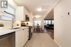 Kitchen with appliances with stainless steel finishes, plenty of natural light, white cabinets, and tasteful backsplash - 