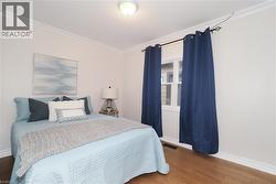 Bedroom featuring ornamental molding and wood finished floors - 