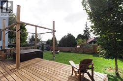 Wooden terrace with a fenced backyard and a hot tub - 