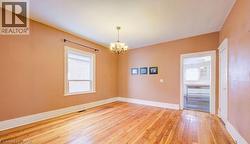 Empty room with a chandelier and wood-type flooring - 