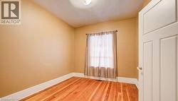 Empty room featuring baseboards and wood-type flooring - 