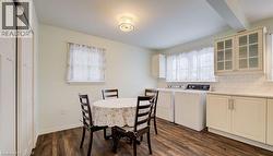 Dining area with dark wood-style floors, washer and clothes dryer, and beam ceiling - 