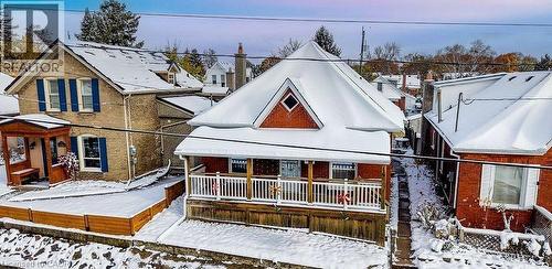 Snow covered rear of property featuring a residential view, a wooden deck, and brick siding - 14 Grandview Street, Brantford, ON - Outdoor
