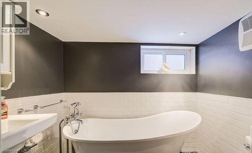 Bathroom featuring a wainscoted wall, tile walls, a soaking tub, and recessed lighting - 14 Grandview Street, Brantford, ON - Indoor Photo Showing Bathroom