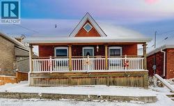 View of front of house featuring covered porch and brick siding - 
