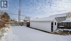 Yard layered in snow with a fenced backyard and an outdoor structure - 