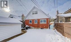 Snow covered rear of property featuring brick siding - 