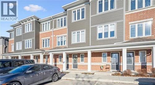View of building exterior featuring uncovered parking and a residential view - 24 Morrison Road Unit# D9, Kitchener, ON - Outdoor With Facade