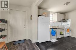 Kitchen with white appliances, white cabinetry, and tasteful backsplash - 