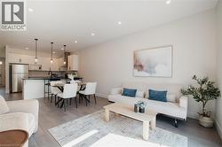 Living area with recessed lighting and light wood-style flooring - 