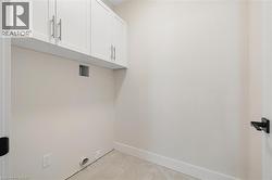 Laundry area featuring cabinet space and light tile patterned floors - 