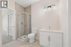 Full bathroom featuring a shower stall, vanity, and light tile patterned floors - 