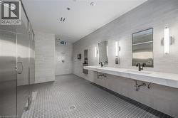 Full bath featuring a stall shower, double vanity, tile walls, and tile patterned flooring - 