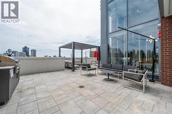 View of patio with area for grilling, an outdoor hangout area, and a city view - 