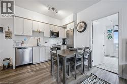 Kitchen featuring light countertops, stainless steel appliances, backsplash, and dark wood-style flooring - 