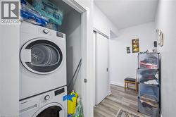 Laundry area with light wood-style floors and stacked washer and clothes dryer - 