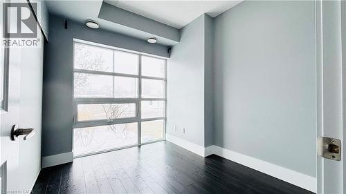 Unfurnished room with wood finished floors and baseboards - 155 St. Leger Unit# 107, Kitchener, ON - Indoor Photo Showing Other Room