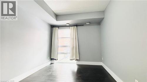 Unfurnished room featuring baseboards and wood finished floors - 155 St. Leger Unit# 107, Kitchener, ON - Indoor Photo Showing Other Room