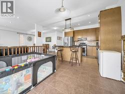 Kitchen featuring a kitchen bar, appliances with stainless steel finishes, decorative light fixtures, decorative backsplash, and recessed lighting - 
