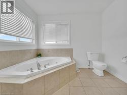 Full bathroom featuring a whirlpool tub and light tile patterned flooring - 