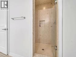 Bathroom featuring a shower stall and light tile patterned floors - 