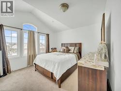 Bedroom featuring light carpet and vaulted ceiling - 