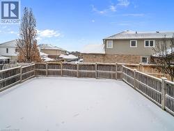 Snowy yard featuring a fenced backyard, a residential view, and a deck - 