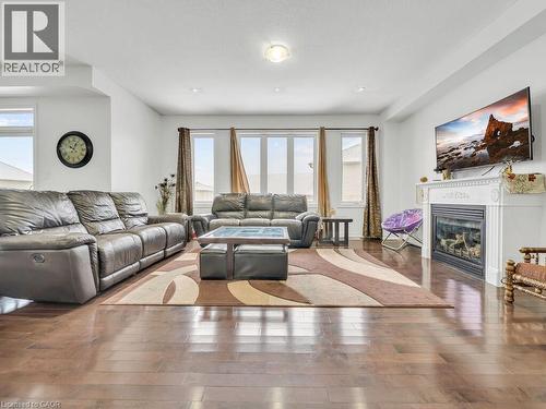 Living area featuring a glass covered fireplace and hardwood / wood-style flooring - 3 Creighton Avenue, Guelph, ON - Indoor Photo Showing Living Room With Fireplace