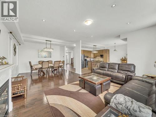 Living area featuring a glass covered fireplace, wood finished floors, and recessed lighting - 3 Creighton Avenue, Guelph, ON - Indoor Photo Showing Living Room With Fireplace