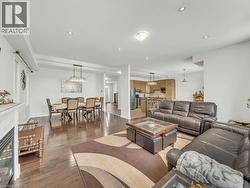 Living area featuring a glass covered fireplace, wood finished floors, and recessed lighting - 