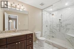 Full bath featuring light marble finish flooring, vanity, and a marble finish shower - 