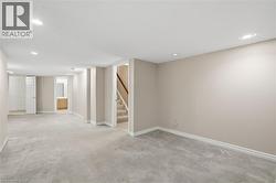 Finished basement with recessed lighting, carpet flooring, and stairway - 