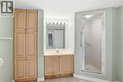 Bathroom with vanity, a stall shower, and light tile patterned flooring - 