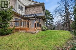 Back of property with brick siding, a wooden deck, and a yard - 