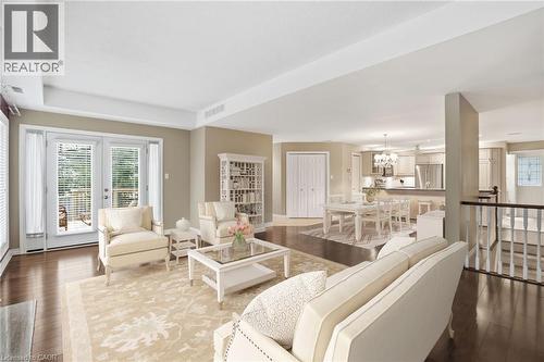 Virtually staged Living area with dark wood finished floors, a tray ceiling, and a chandelier in dining rm - 3230 New Street Unit# 7, Burlington, ON - Indoor Photo Showing Living Room