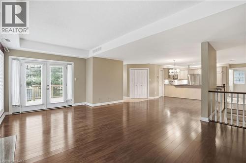 Unfurnished living room featuring dark wood-style floors and a chandelier - 3230 New Street Unit# 7, Burlington, ON - Indoor Photo Showing Other Room