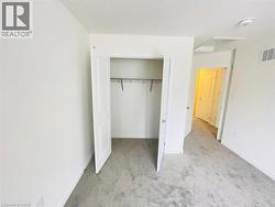 Unfurnished bedroom featuring light carpet and a closet - 