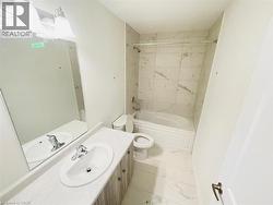 Full bath featuring shower / washtub combination, vanity, and light marble finish floors - 
