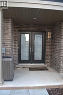 Entrance to property featuring brick siding and a porch - 