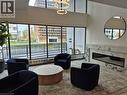 Spacious common area featuring floor-to-ceiling windows, a contemporary electric fireplace with a marble surround, and recessed lighting - 150 Charlton Avenue E Unit# 402, Hamilton, ON  - Indoor With Fireplace 