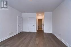 Unfurnished bedroom with dark hardwood / wood-style flooring - 