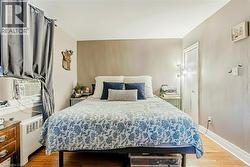 Bedroom featuring light wood-style flooring, radiator heating unit, and cooling unit - 