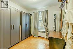 Unfurnished bedroom with light wood-style floors and radiator - 