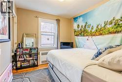 Bedroom with wood finished floors and radiator - 