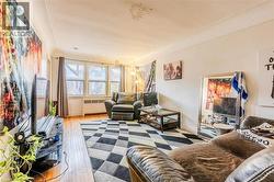 Living area featuring hardwood / wood-style flooring and radiator - 