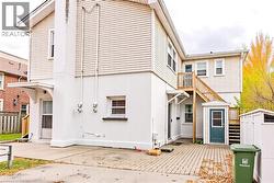Back of house with stucco siding and an outdoor structure - 