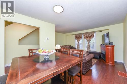 Dining space with dark wood-type flooring, a textured ceiling, and a glass covered fireplace - 85 Enmount Drive, Brampton, ON - Indoor Photo Showing Dining Room