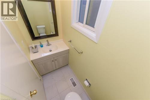 Half bath with vanity and light tile patterned floors - 85 Enmount Drive, Brampton, ON - Indoor Photo Showing Bathroom