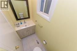 Half bath with vanity and light tile patterned floors - 